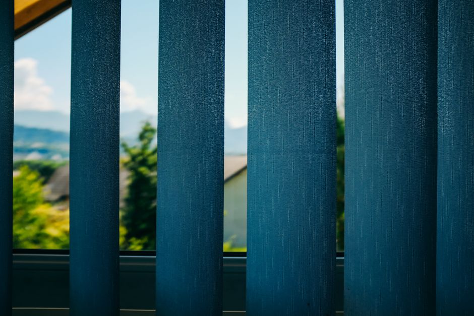Warm sunlight filtering softly through modern window blinds